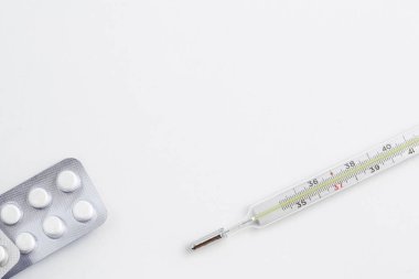 Eski bir cıva termometre beyaz izole arka planda ilaçlarla. Üstten Görünüm