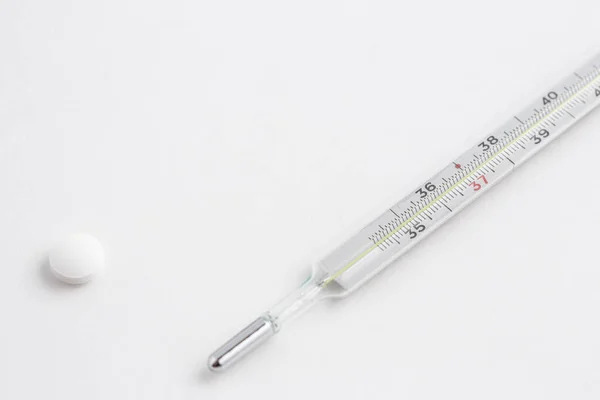 An old mercury thermometer with medicines on a white isolated background. Top view