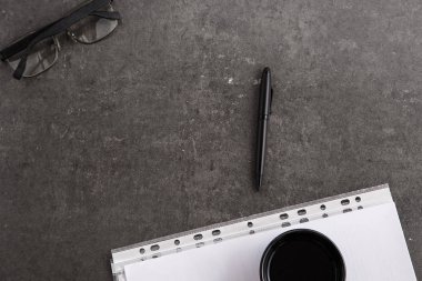 Kahve ve siyah kalem gri mermer zemin üzerine belgelerdeki fincan sade. Üstten Görünüm