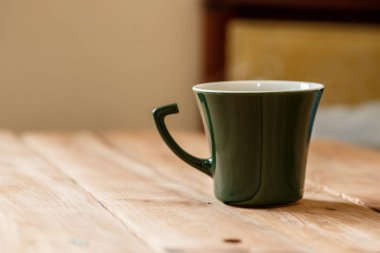 Sabah kahve koyu yeşil şık Kupası bir tahta üzerinde arka plan dokulu. Kış güneş ışığı ışınlarının fotoğrafı