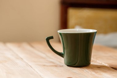 Sabah kahve koyu yeşil şık Kupası bir tahta üzerinde arka plan dokulu. Kış güneş ışığı ışınlarının fotoğrafı