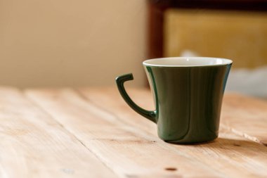 Sabah kahve koyu yeşil şık Kupası bir tahta üzerinde arka plan dokulu. Kış güneş ışığı ışınlarının fotoğrafı