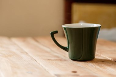 Sabah kahve koyu yeşil şık Kupası bir tahta üzerinde arka plan dokulu. Kış güneş ışığı ışınlarının fotoğrafı