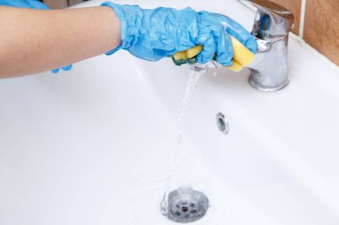 Kadınların mavi eldivenli elleri ile özel bir lavabo lavabo temiz yıkamak.