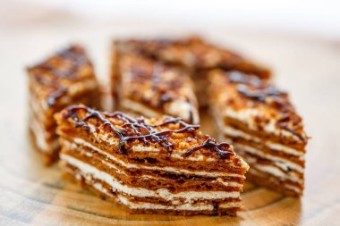 Dilim kek katmanları ahşap bir masa üzerinde tuval üzerine krema ile