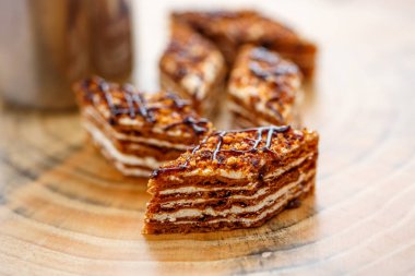 Dilim kek katmanları ile bir bardak çay ahşap bir masa üzerinde krem ile