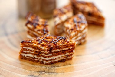 Dilim kek katmanları ile bir bardak çay ahşap bir masa üzerinde krem ile