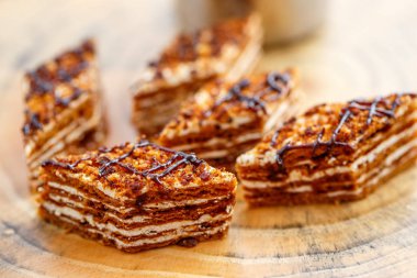 Dilim kek katmanları ile bir bardak çay ahşap bir masa üzerinde krem ile