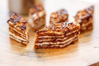 Dilim kek katmanları ile bir bardak çay ahşap bir masa üzerinde krem ile