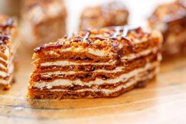 Dilim kek katmanları ile bir bardak çay ahşap bir masa üzerinde krem ile