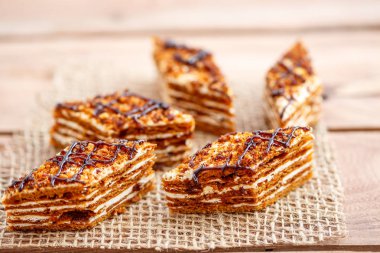 Dilim kek katmanları ahşap bir masa üzerinde tuval üzerine krema ile