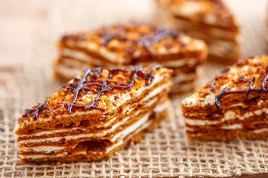 Dilim kek katmanları ahşap bir masa üzerinde tuval üzerine krema ile