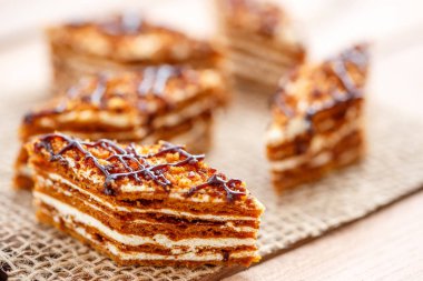 Dilim kek katmanları ahşap bir masa üzerinde tuval üzerine krema ile