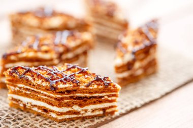 Dilim kek katmanları ahşap bir masa üzerinde tuval üzerine krema ile