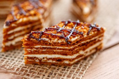 Dilim kek katmanları ahşap bir masa üzerinde tuval üzerine krema ile