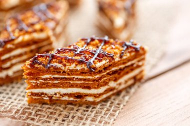 Dilim kek katmanları ahşap bir masa üzerinde tuval üzerine krema ile