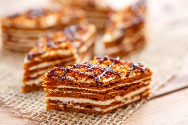 Dilim kek katmanları ahşap bir masa üzerinde tuval üzerine krema ile