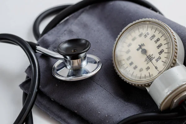 Concept for medicine. Vintage tonometer and stethoscope on white isolated background. View from above