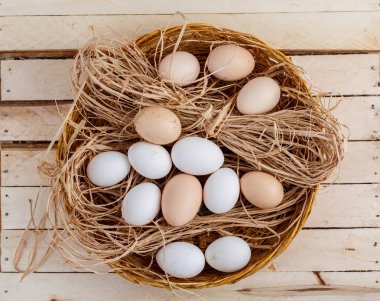 Taze yumurta saman ahşap arka plan ile sepet içinde. Olan bir alana metin için.