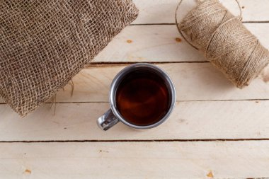 Sıcak içecek ahşap arka plan üzerinde vintage bir kupa. Yukarıdan görüntülemek.