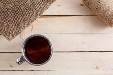 Sıcak içecek ahşap arka plan üzerinde vintage bir kupa. Yukarıdan görüntülemek.