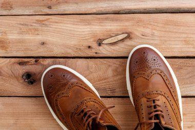 Erkek ayakkabıları ahşap arka plan üzerinde kahverengi. Üstten Görünüm