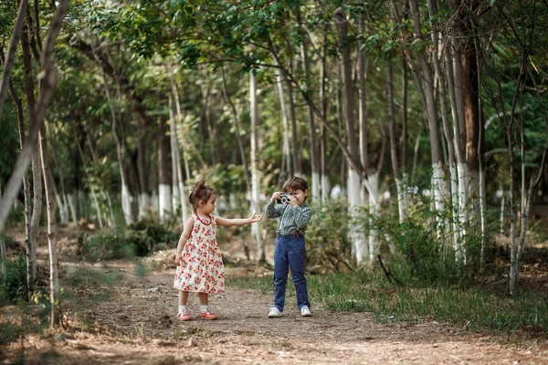 Photo shoot in vintage style. Boy and girl in vintage clothes with vintage accessories on abandoned railway and train station