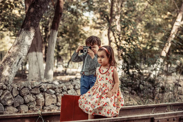 ビンテージ スタイルで写真撮影 男の子と女の子に放棄された鉄道と鉄道駅のヴィンテージアクセサリー ヴィンテージ服 — ストック写真