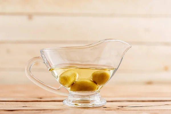 Olive oil in a beautiful oil can on a wooden background