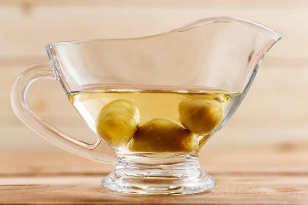 Olive oil in a beautiful oil can on a wooden background