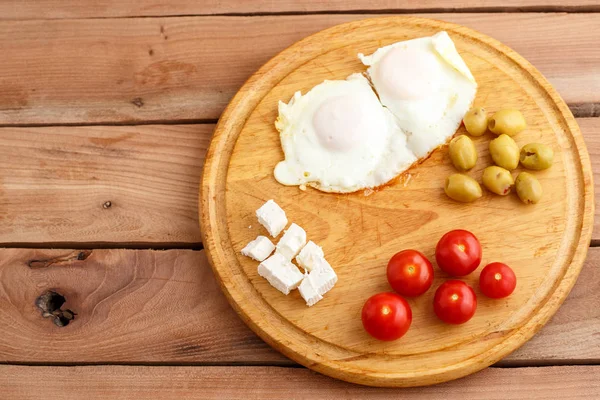 Śniadanie Smażone Jajka Pomidory Oliwki Ser Drewnianej Tablicy Widok Góry — Zdjęcie stockowe