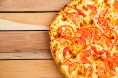 Pizza domates bir ahşap tepsi ahşap arka plan üzerinde. Üstten Görünüm