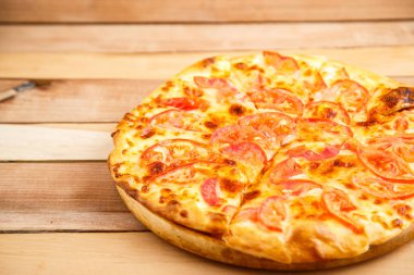 Pizza domates bir ahşap tepsi ahşap arka plan üzerinde. Üstten Görünüm