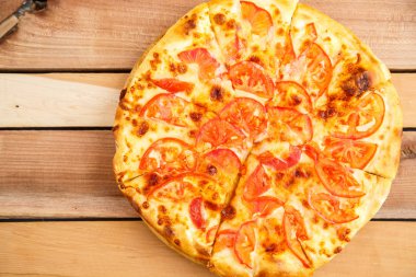 Pizza domates bir ahşap tepsi ahşap arka plan üzerinde. Üstten Görünüm