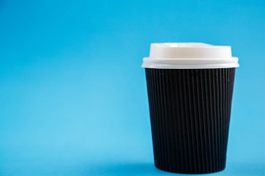 Mavi bir arka plan üzerinde izole karton tek kullanımlık bardak. Önden Görünüm