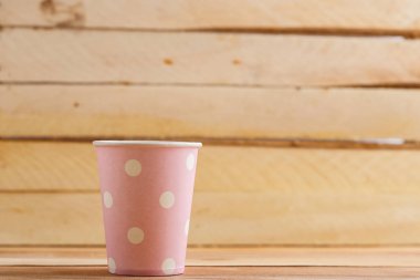 Ahşap arka plan üzerinde izole karton tek kullanımlık bardak. Önden Görünüm