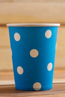 Ahşap arka plan üzerinde izole karton tek kullanımlık bardak. Önden Görünüm