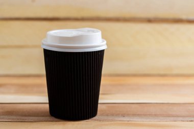 Ahşap arka plan üzerinde izole karton tek kullanımlık bardak. Önden Görünüm