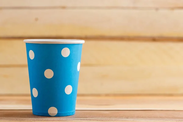 Cardboard disposable cups isolated on a wooden background. Front view