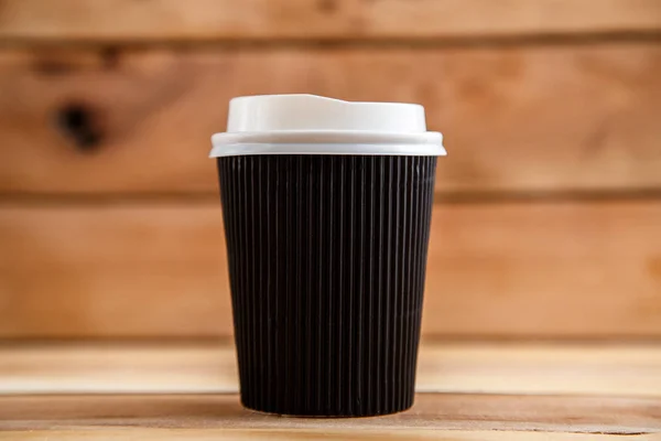 Cardboard disposable cups isolated on a wooden background. Front view