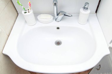 Banyoda lavabo, diş fırçası ve sıvı sabun