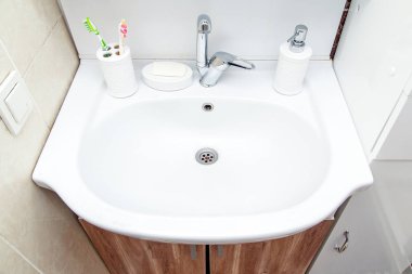 Banyoda lavabo, diş fırçası ve sıvı sabun