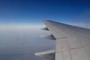 Sabah bulutlarının üzerinde uçan bir uçağın kanadı