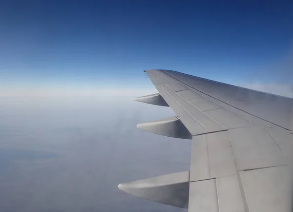 Sabah bulutlarının üzerinde uçan bir uçağın kanadı — Stok fotoğraf