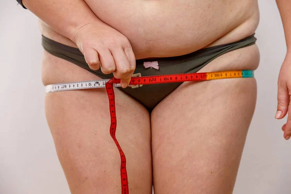 一名中年妇女穿着内裤超重测量她的身体 — 图库照片