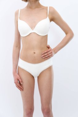 Ön manzara. Beyaz iç çamaşırlı zayıf, genç bir kız kendini gösteriyor.