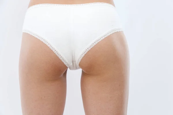 Rear view. slim young athletic girl in white lingerie shows her — Stock Photo, Image