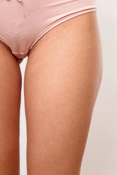 Jonge vrouw in lingerie met ongeschoren schaamhaar op witte isolat — Stockfoto