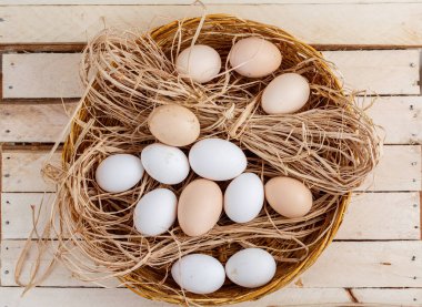 ahşap bir arka plan üzerinde saman çiğ yumurta