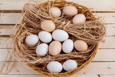 ahşap bir arka plan üzerinde saman çiğ yumurta